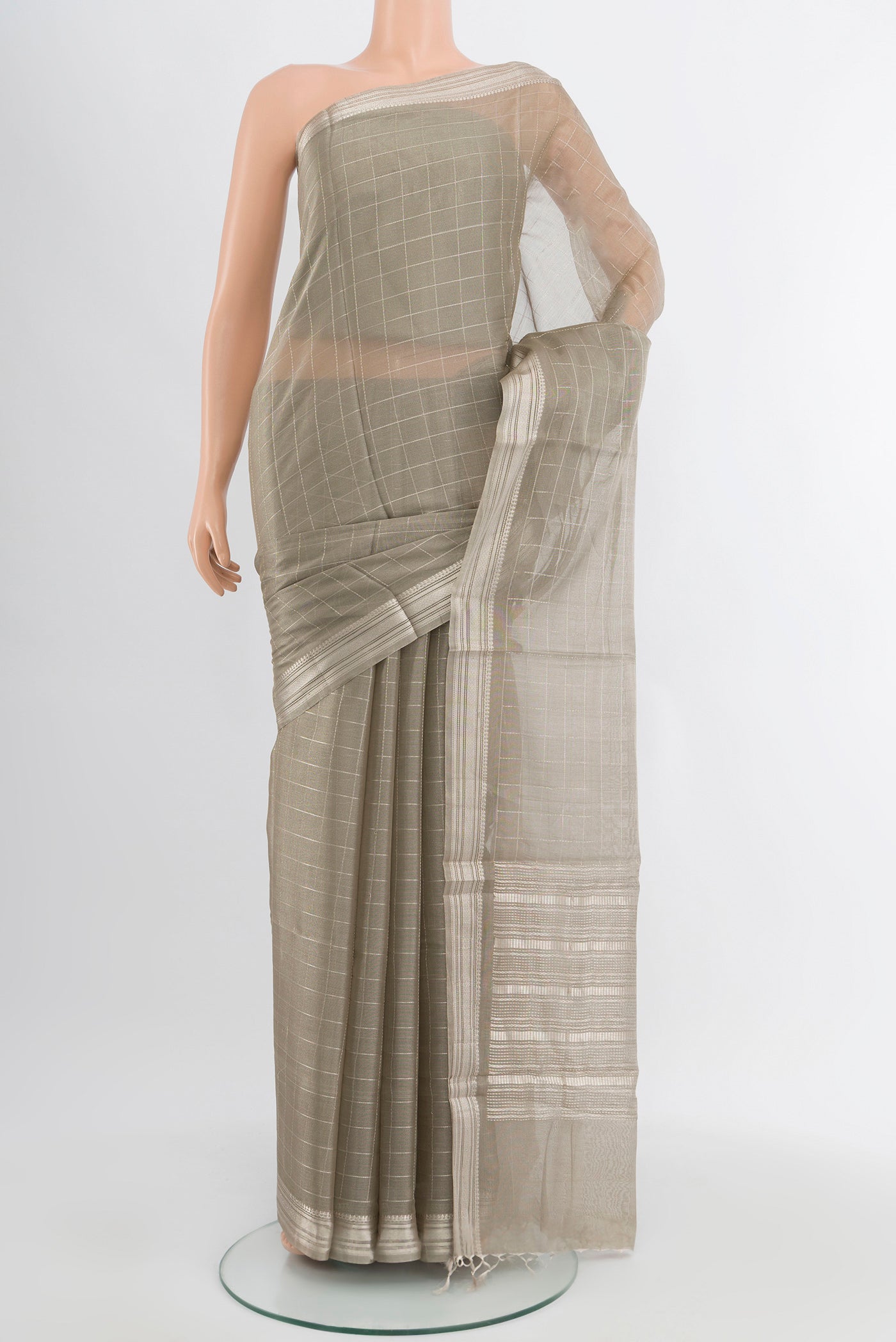 Grey Tussar Silk Saree with Zari Butta on the body and Silk Border.  displayed on a mannequin