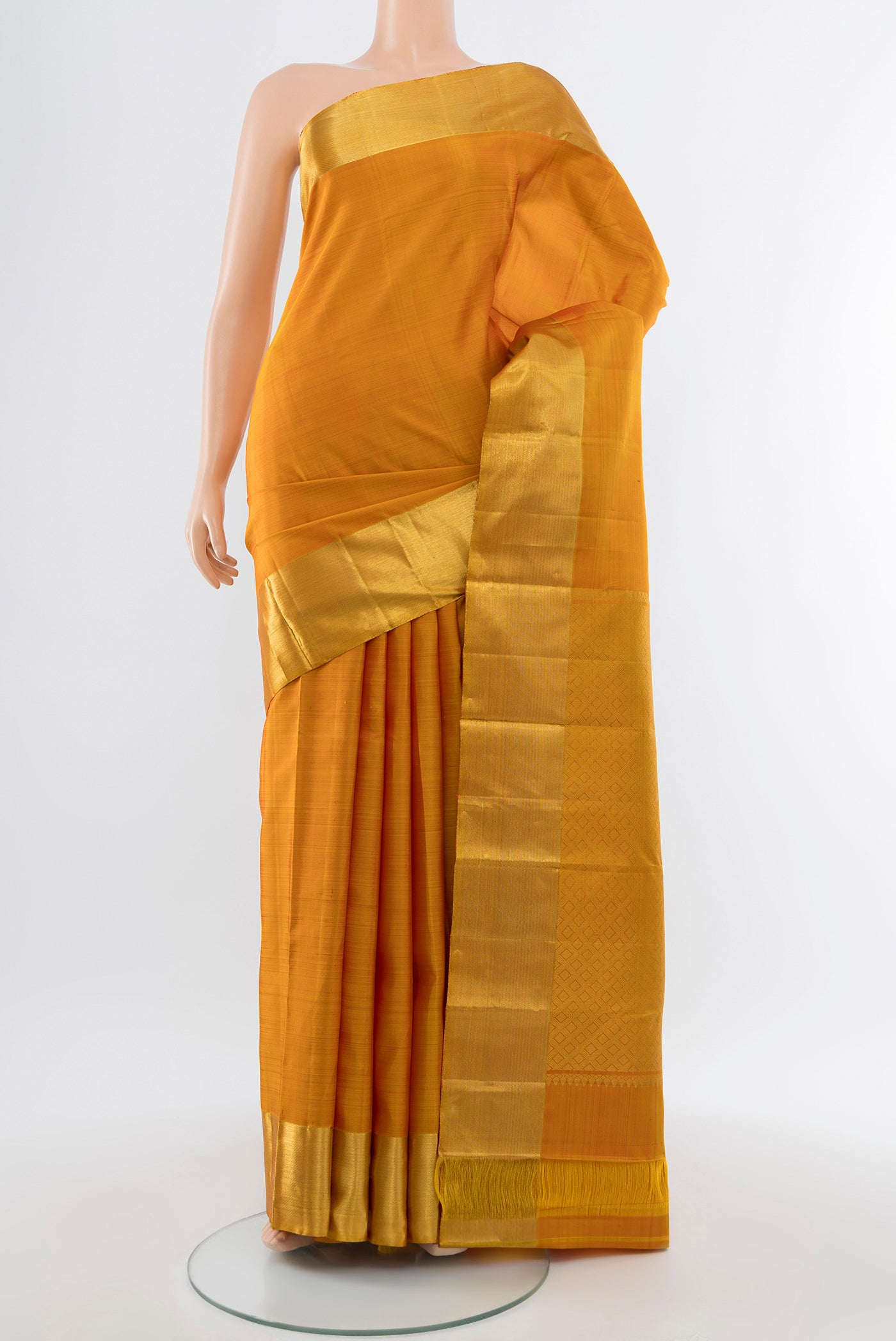 Mustard Kanjivaram Silk Saree with Zari Butta on the body and Silk Border.  displayed on a mannequin