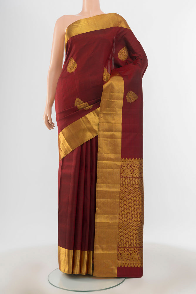 Pure Silk Pure Zari Maroon Kanchipuram Saree with Zari Butta on the body and Silk Border.  displayed on a mannequin