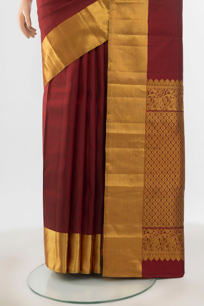 Pleats and pallu of Pure Silk Pure Zari Maroon Kanchipuram Saree with Zari Butta on the body and Silk Border. 