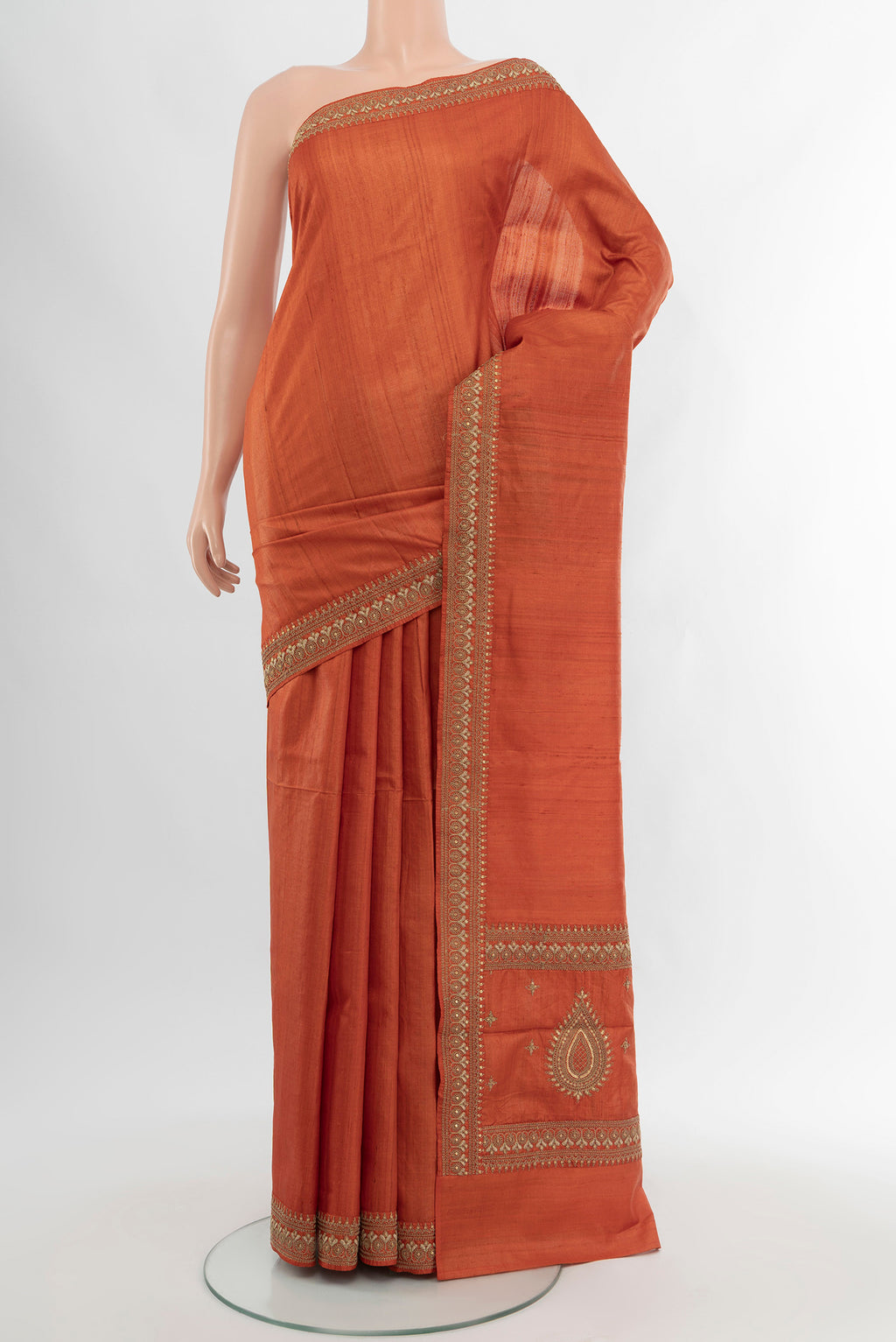 Rust Tussar Silk Saree with Plain Body and Embroidery Border.  displayed on a mannequin