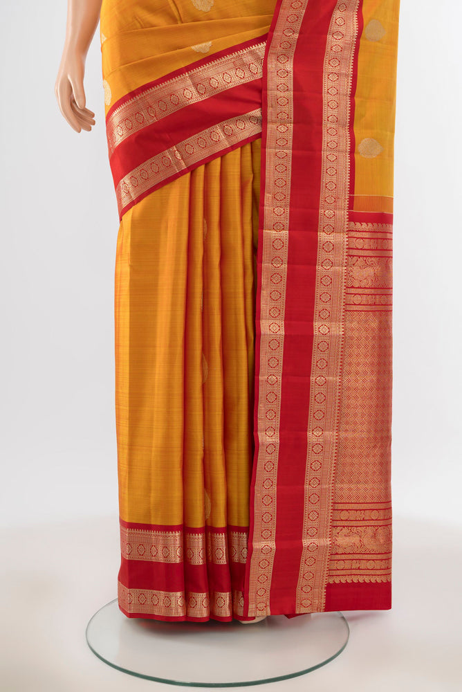 Pleats and pallu of Pure Silk Pure Zari Yellow Kanjivaram Saree with Zari Butta on the body and Silk Border. 