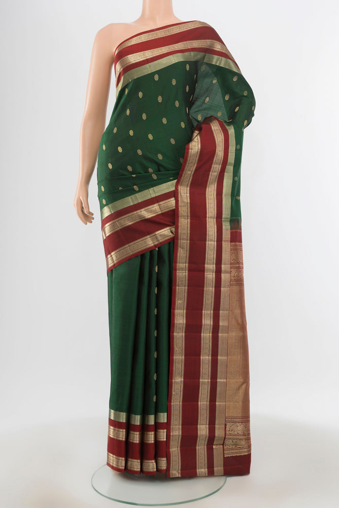 Pure Silk Pure Zari Bottle Green Kanjivaram Saree with Zari Butta on the body and Silk Border.  displayed on a mannequin