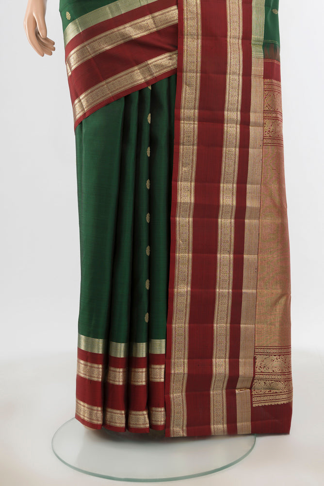 Pleats and pallu of Pure Silk Pure Zari Bottle Green Kanjivaram Saree with Zari Butta on the body and Silk Border. 