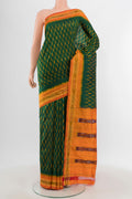 Bottle Green Pochampally Silk Saree with Ikat design on the body and Ikat Border.  displayed on a mannequin