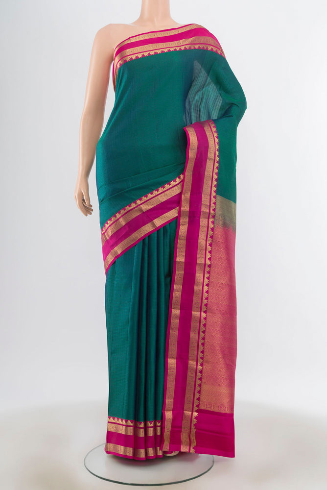 Peacock Blue Kanchipuram Silk Saree with Zari Butta on the body and Silk Border.  displayed on a mannequin