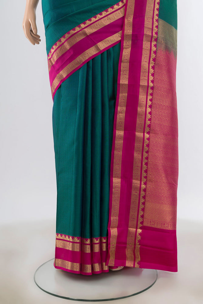 Pleats and pallu of Peacock Blue Kanchipuram Silk Saree with Zari Butta on the body and Silk Border. 