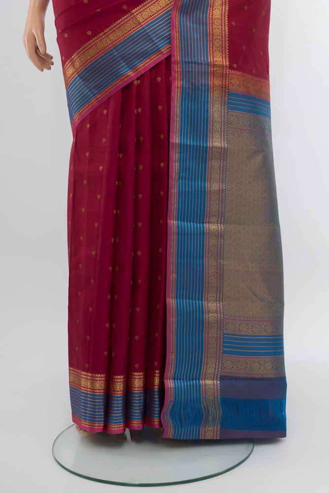 Pleats and pallu of Maroon Kanchipuram Silk Saree with Zari Butta on the body and Silk Border. 