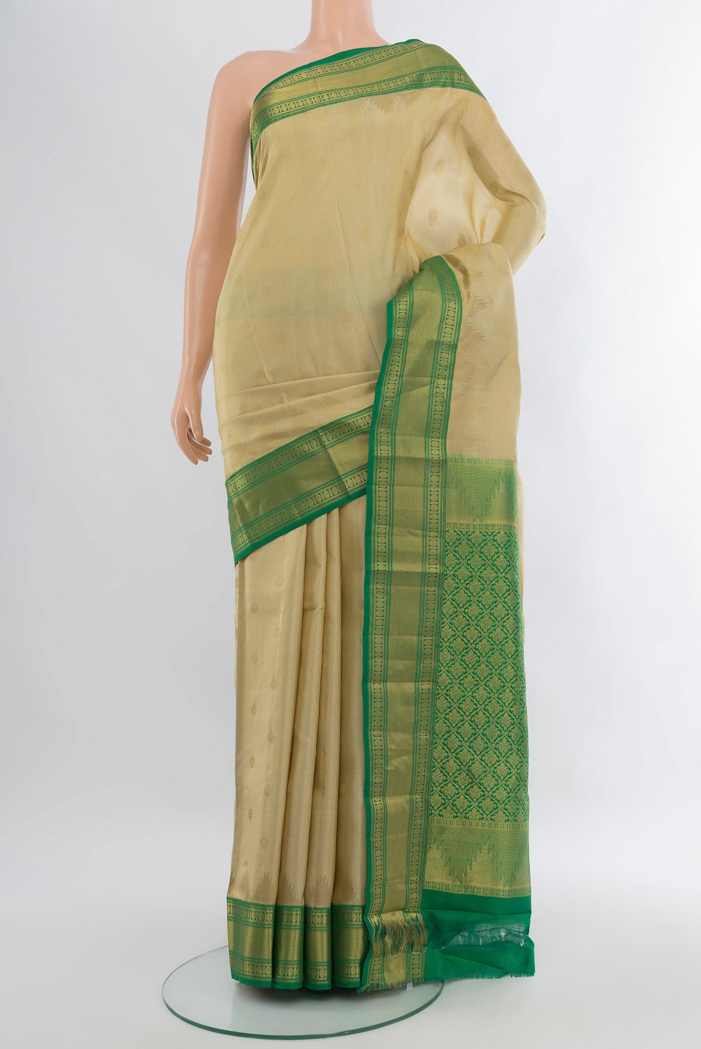 Cream Kanchipuram Silk Saree with Zari Butta on the body and Zari Border.  displayed on a mannequin
