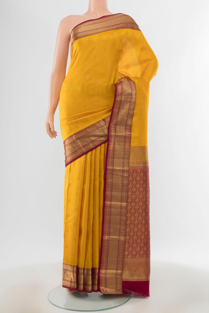 Pure Silk Pure Zari Mustard Kanchipuram Saree with Zari Butta on the body and Silk Border.  displayed on a mannequin