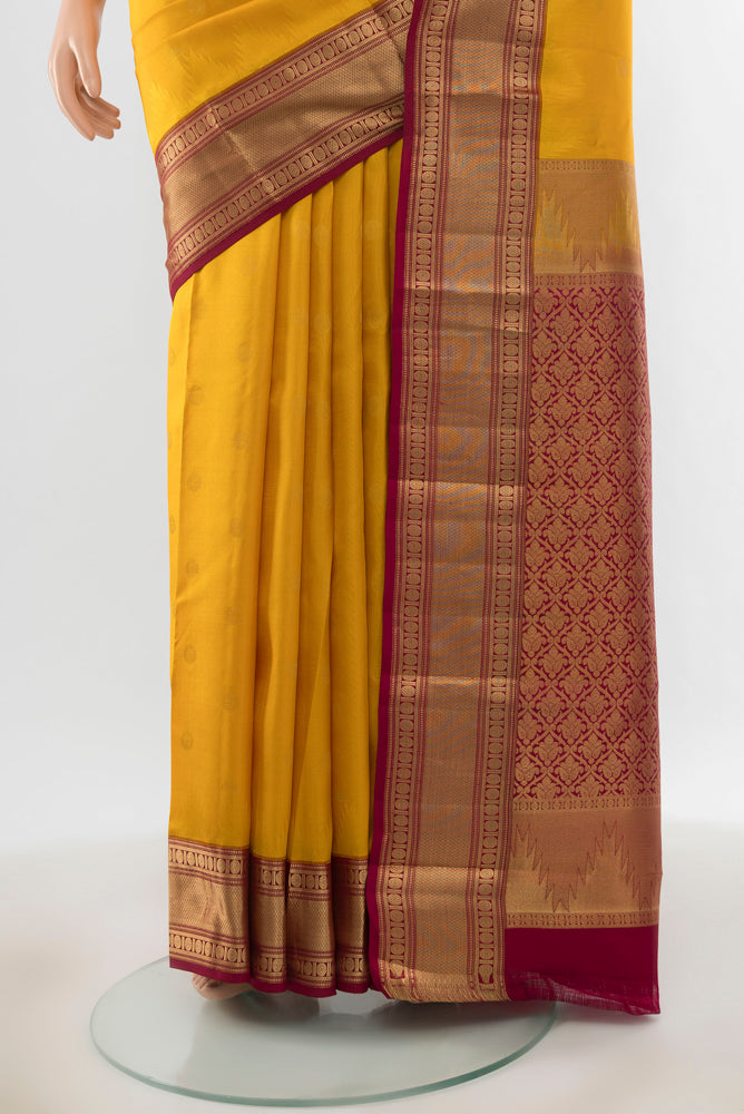 Pleats and pallu of Pure Silk Pure Zari Mustard Kanchipuram Saree with Zari Butta on the body and Silk Border. 