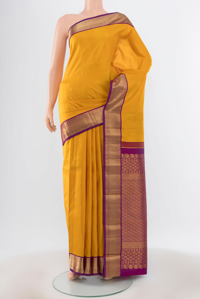 Pure Silk Pure Zari Yellow Kanchipuram Saree with Zari Butta on the body and Silk Border.  displayed on a mannequin