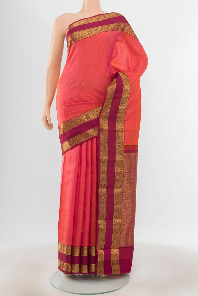 Pure Silk Pure Zari Peach Kanchipuram Saree with Zari Butta on the body and Silk Border.  displayed on a mannequin