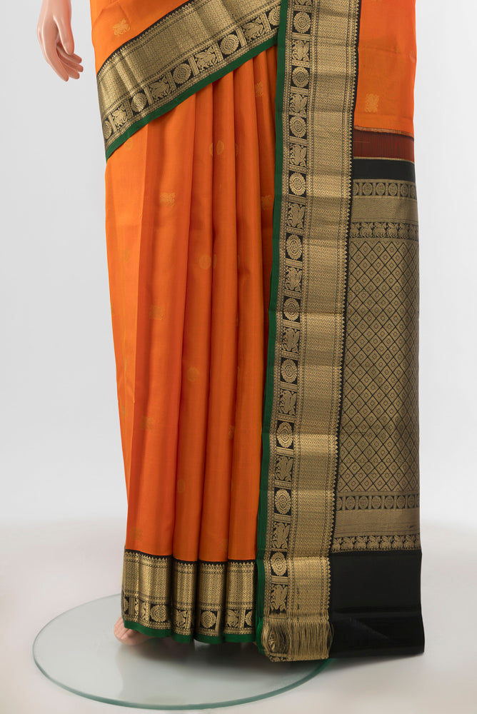 Pleats and pallu of Brick Orange Kanchipuram Silk Saree with Zari Butta on the body and Silk Border. 