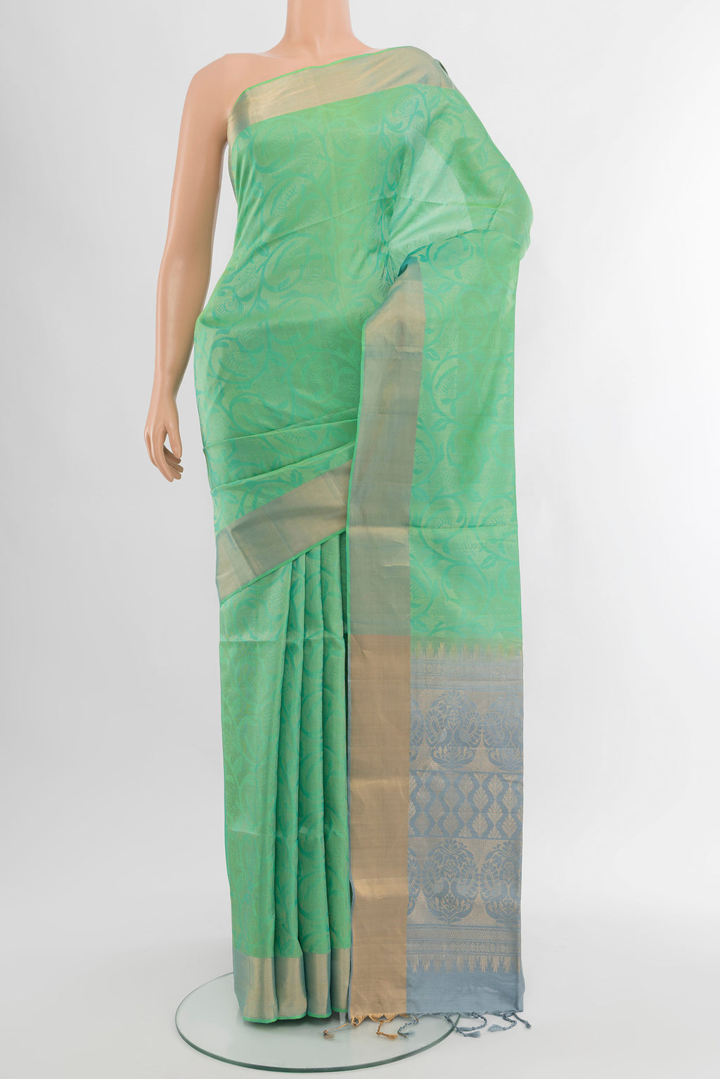 Light Green Soft Silk Saree with Zari Butta on the body and Silk Border.  displayed on a mannequin