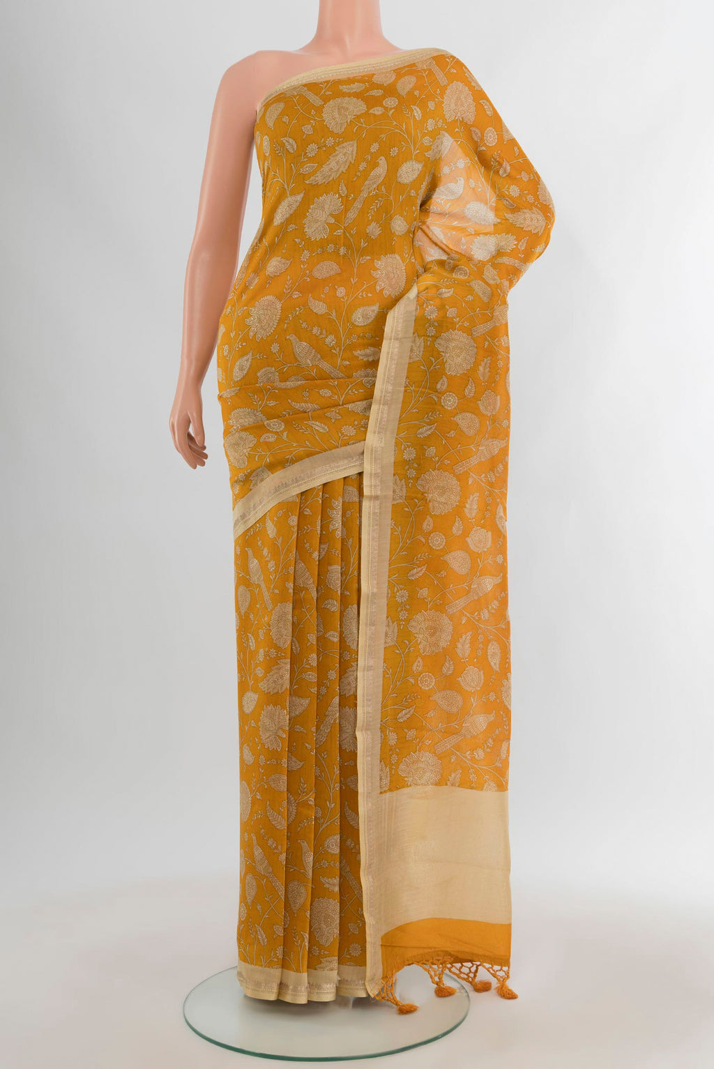 Mustard Maheshwari Silk Cotton Saree with Floral Print on the body and Zari Border.  displayed on a mannequin