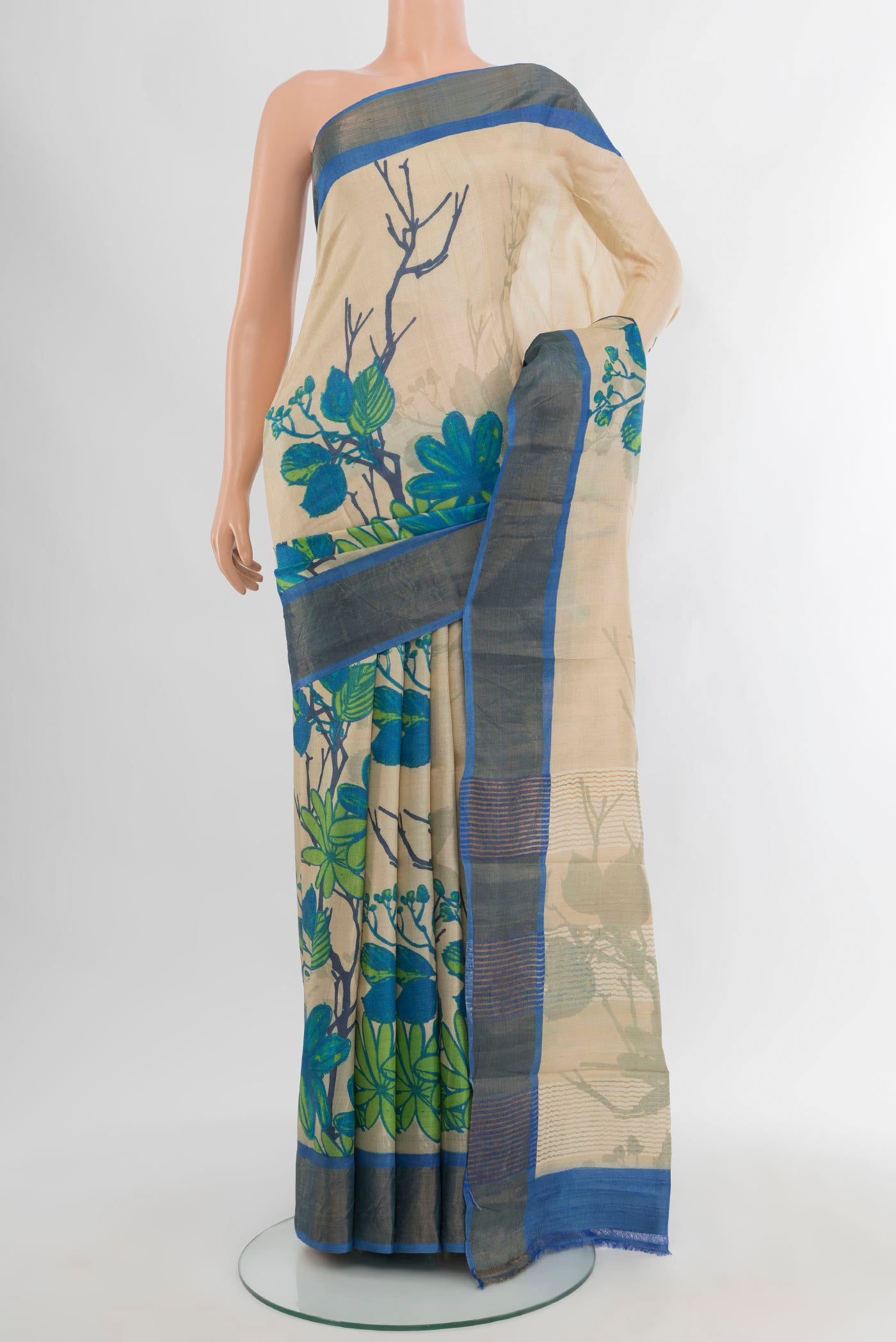 Beige Tussar Silk Saree with Floral Print on the body and Zari Border.  displayed on a mannequin