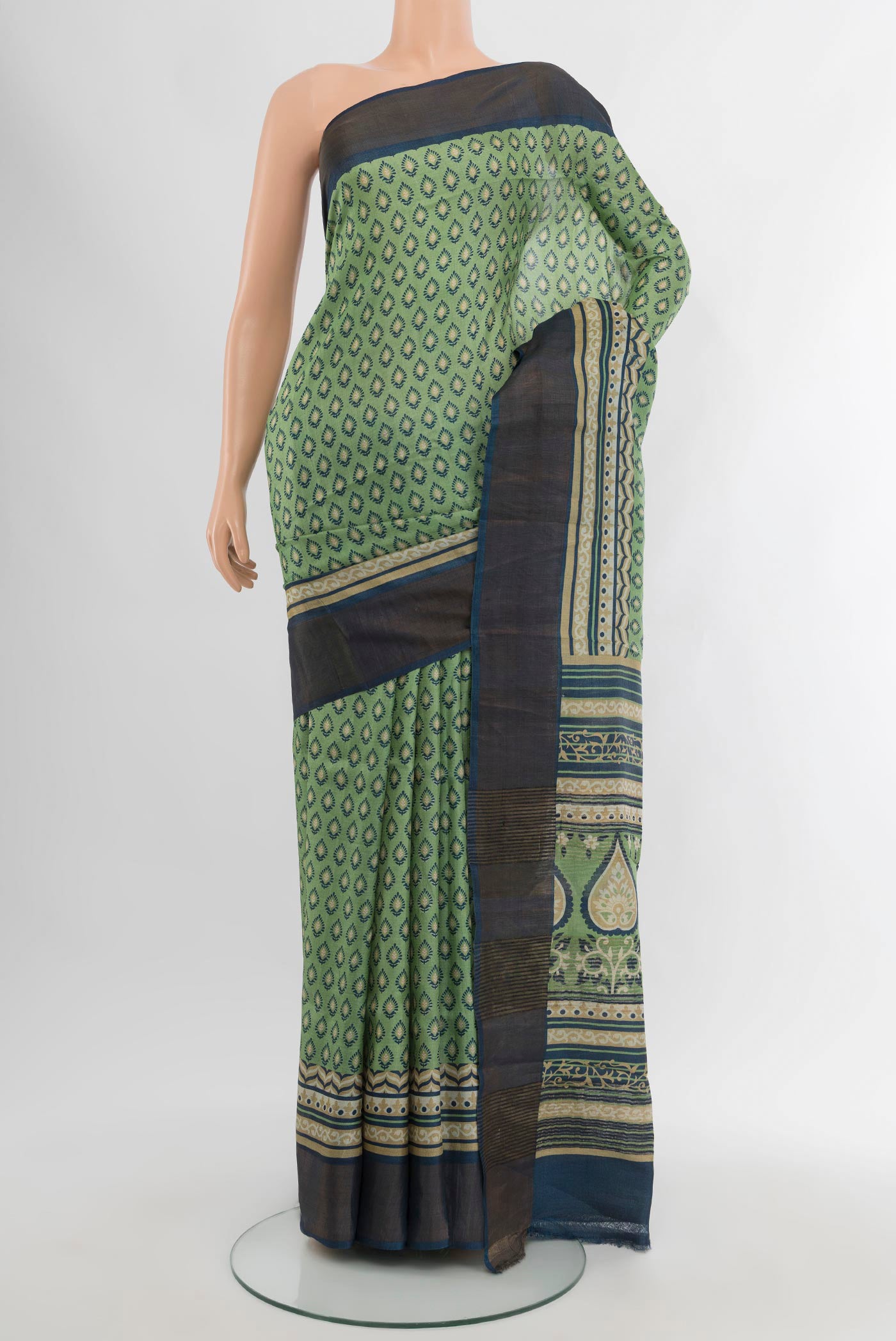 Sage Green Tussar Silk Saree with Floral Print on the body and Zari Border.  displayed on a mannequin