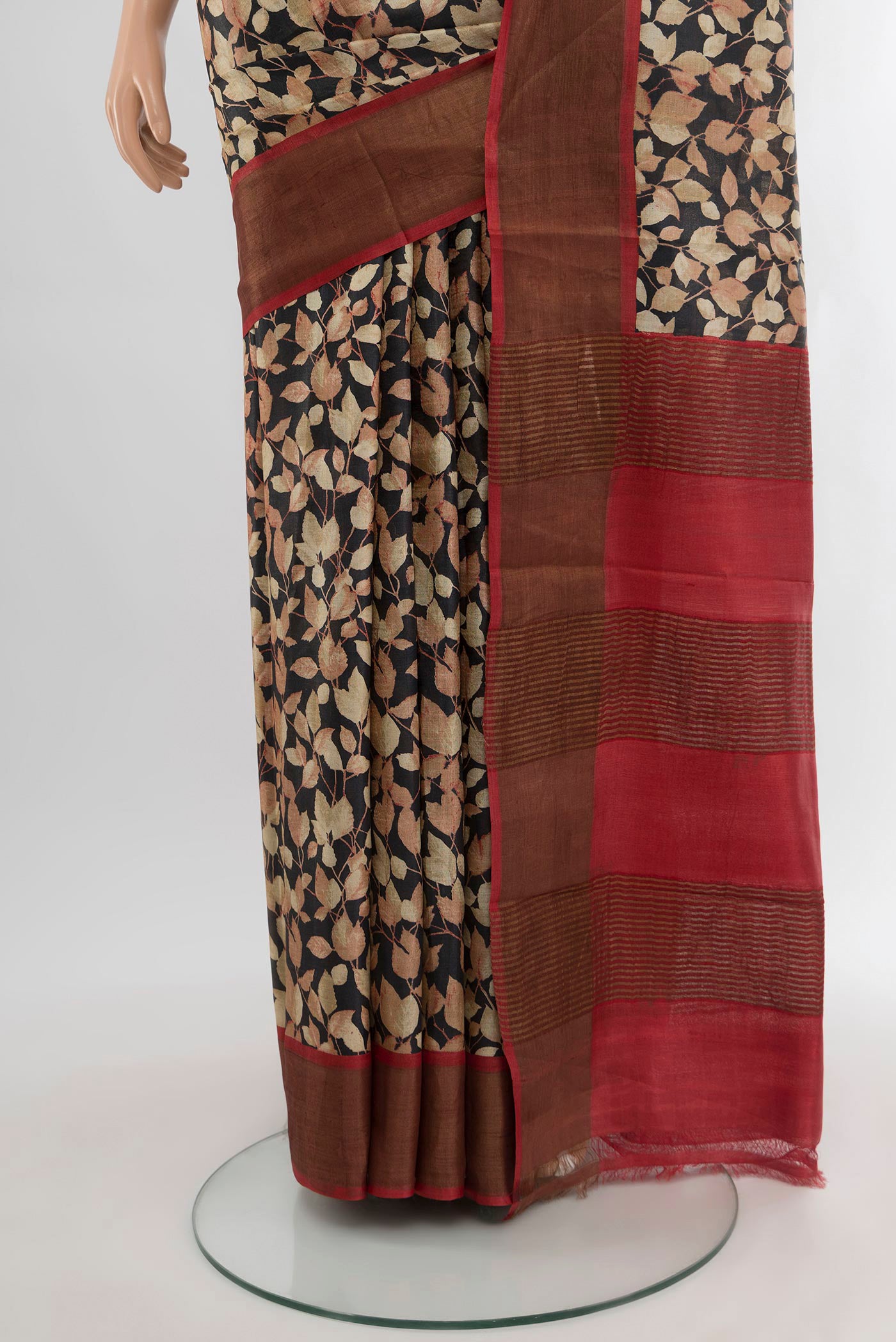 Pleats and pallu of Black Tussar Silk Saree with Floral Print on the body and Zari Border. 
