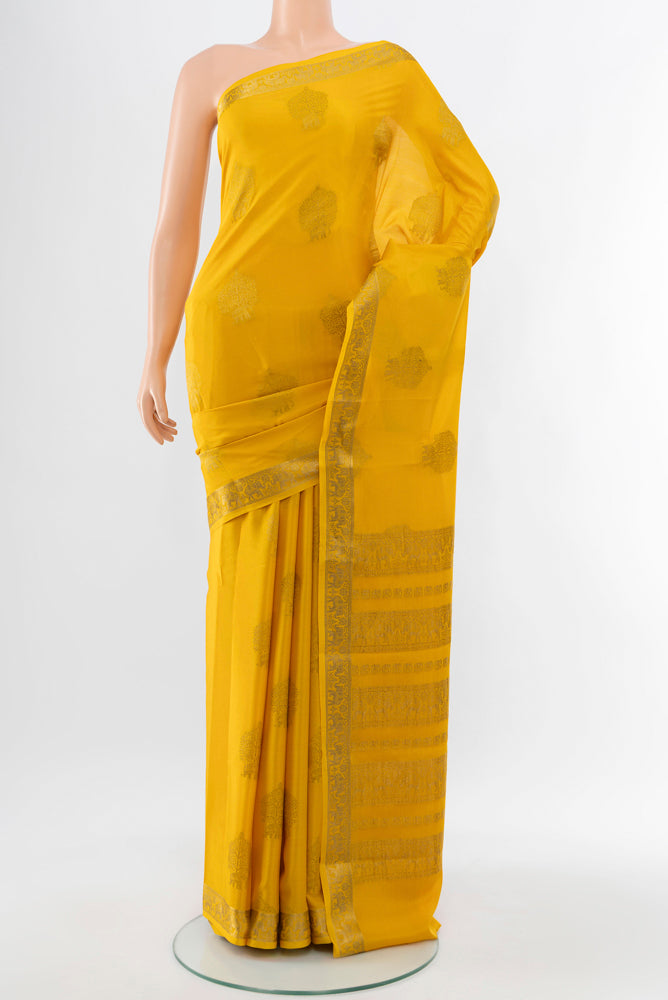 Yellow Mysore Crepe Saree with Zari Butta on the body and Silk Border.  displayed on a mannequin