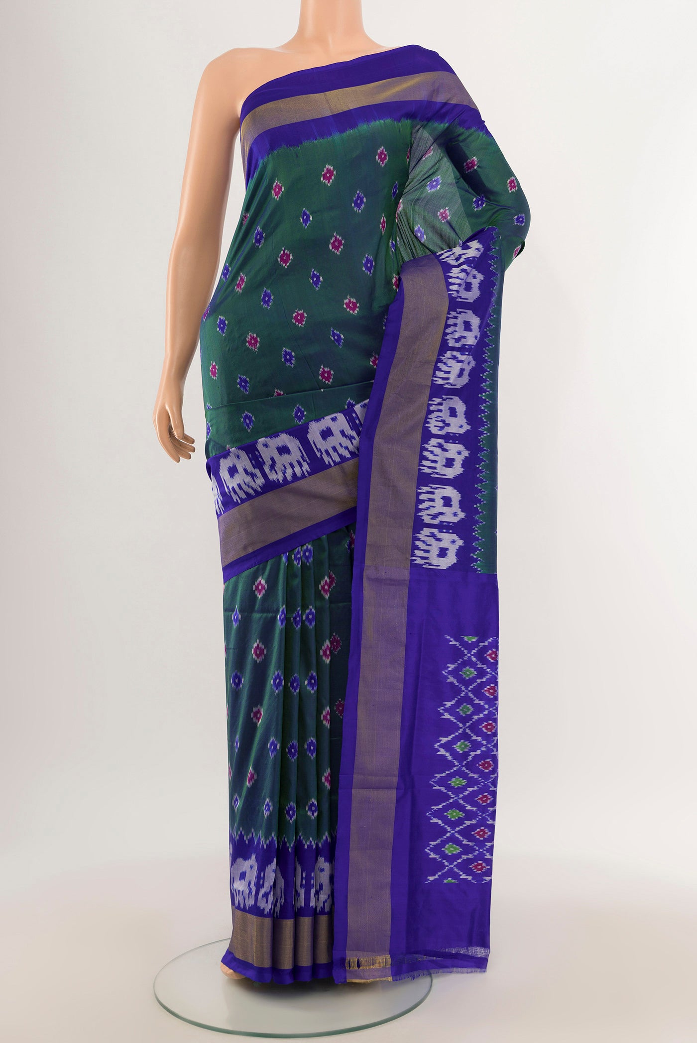 Green Pochampally Silk Saree with Ikat design on the body and Ikat Border.  displayed on a mannequin