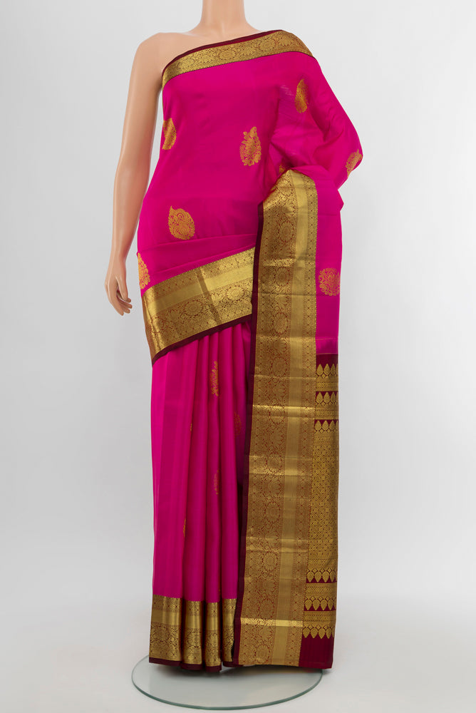 Dark Pink Kanchipuram Silk Saree with Zari Butta on the body and Silk Border.  displayed on a mannequin