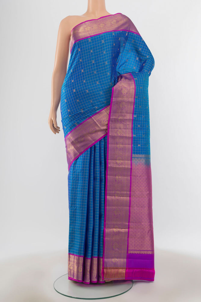 Pure Silk Pure Zari Light Blue Kanchipuram Saree with Zari Butta on the body and Silk Border.  displayed on a mannequin