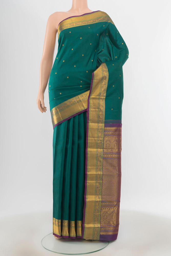 Pure Silk Pure Zari Peacock Blue Kanjivaram Saree with Zari Butta on the body and Silk Border.  displayed on a mannequin