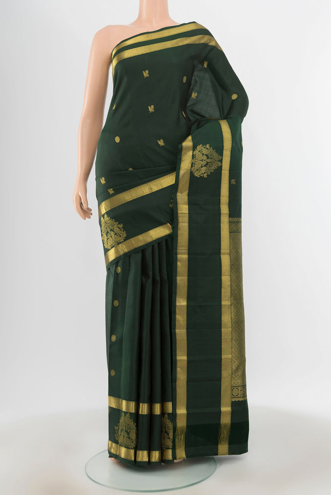 Pure Silk Pure Zari Bottle Green Kanjivaram Saree with Zari Butta on the body and Silk Border.  displayed on a mannequin