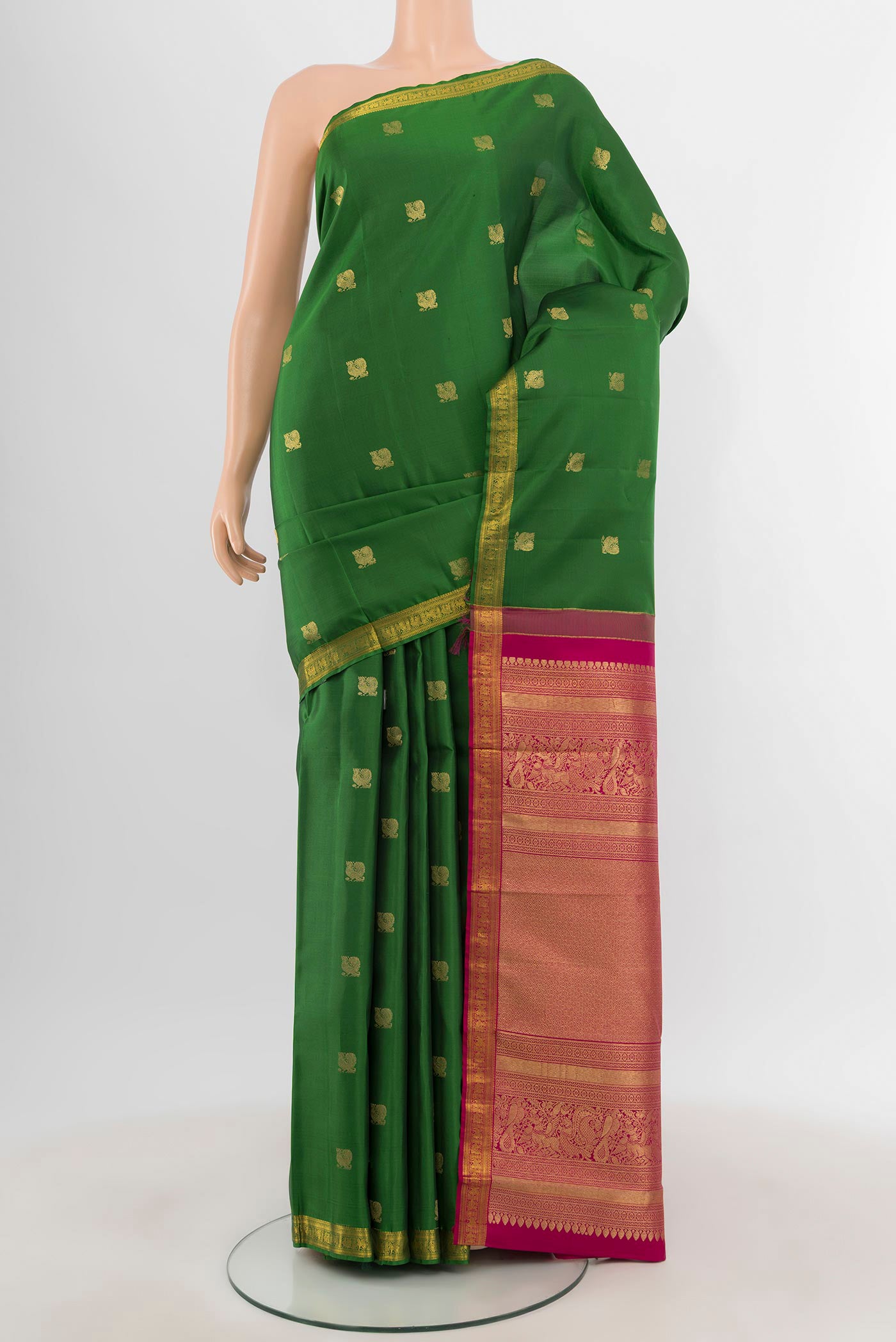 Green Kanchipuram Silk Saree with Zari Butta on the body and Zari Border.  displayed on a mannequin