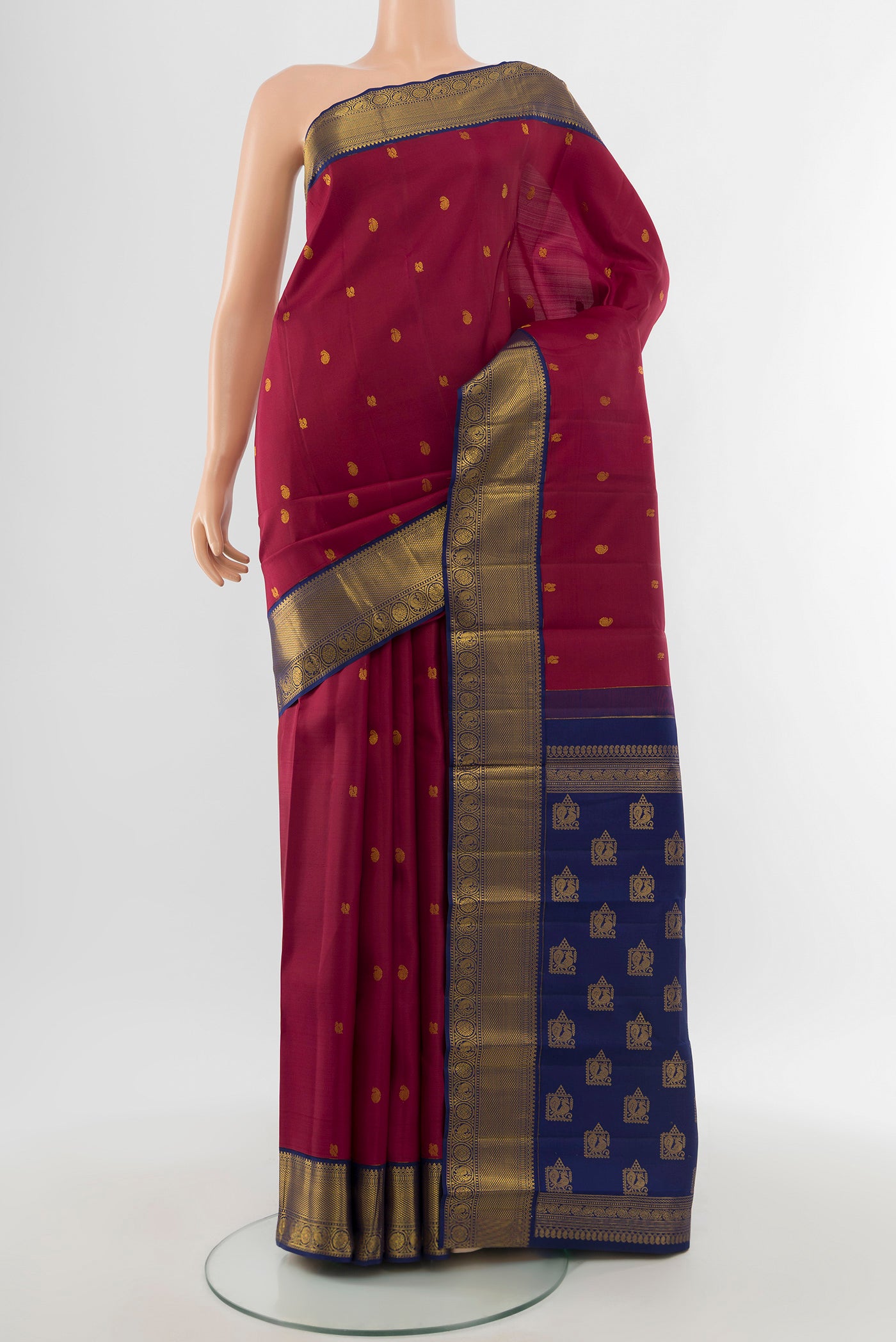 Pure Silk Pure Zari Maroon Kanjivaram Saree with Zari Butta on the body and Silk Border.  displayed on a mannequin