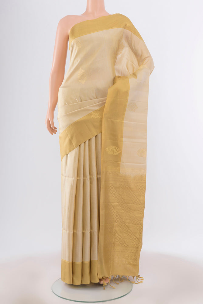 Cream Soft Silk Saree with Zari Butta on the body and Silk Border.  displayed on a mannequin
