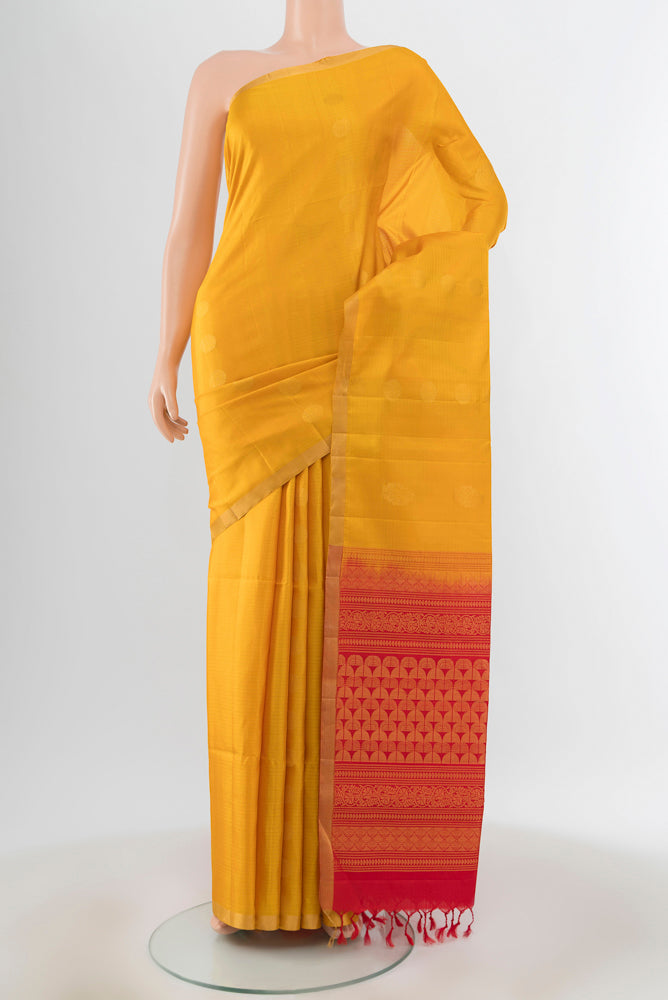Yellow Soft Silk Saree with Zari Butta on the body and Silk Border.  displayed on a mannequin