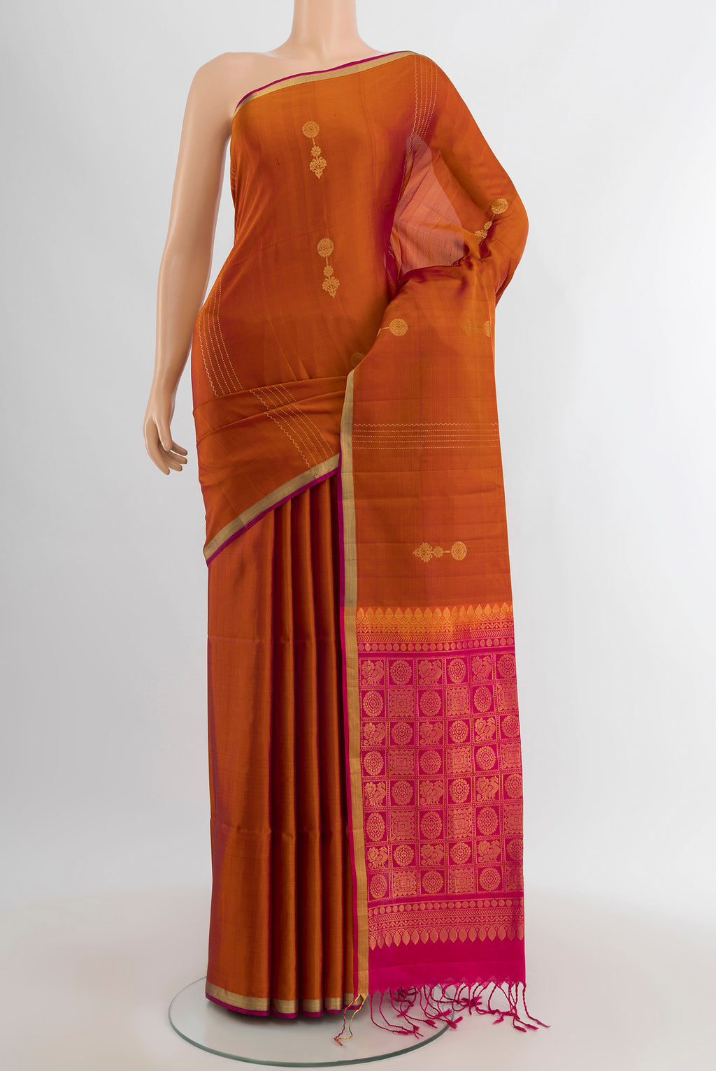 Rust Soft Silk Saree with Zari Butta on the body and Zari Border.  displayed on a mannequin