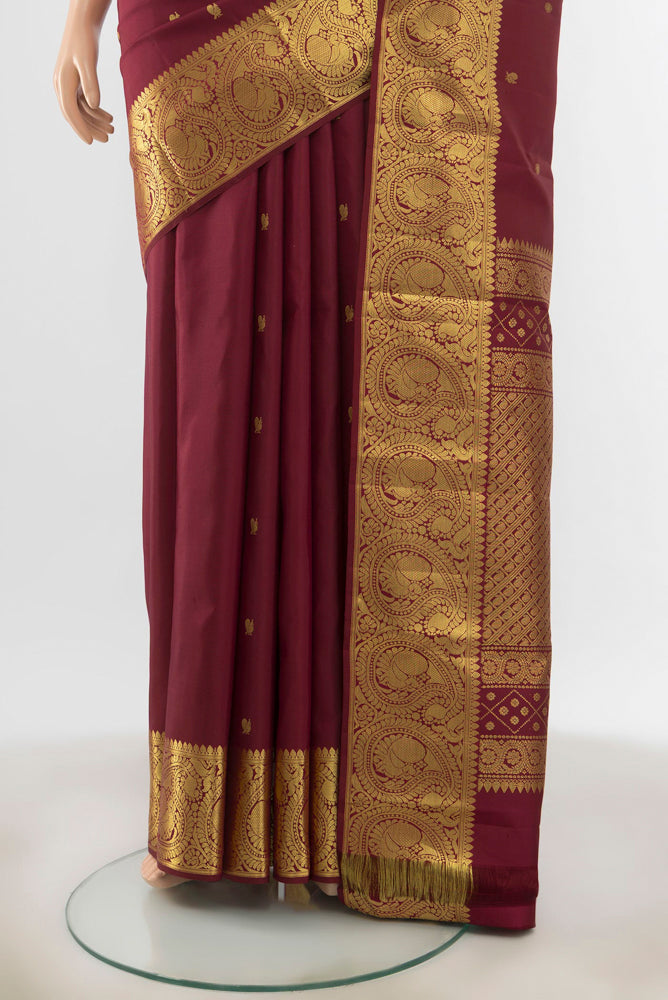 Pleats and pallu of Maroon Kanchipuram Silk Saree with Zari Butta on the body and Silk Border. 