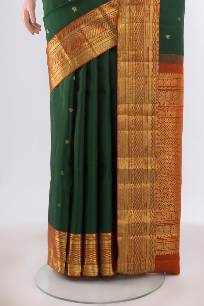 Pleats and pallu of Bottle Green Kanchipuram Silk Saree with Zari Butta on the body and Silk Border. 