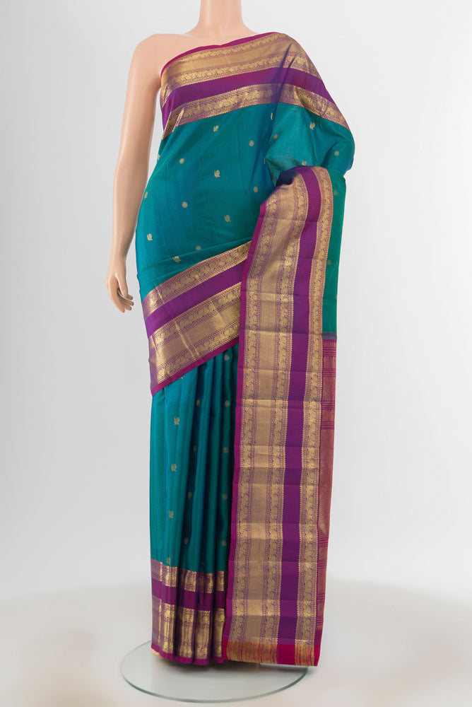 Peacock Blue Kanchipuram Silk Saree with Zari Butta on the body and Silk Border.  displayed on a mannequin