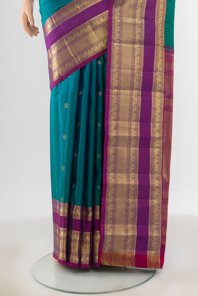 Pleats and pallu of Peacock Blue Kanchipuram Silk Saree with Zari Butta on the body and Silk Border. 