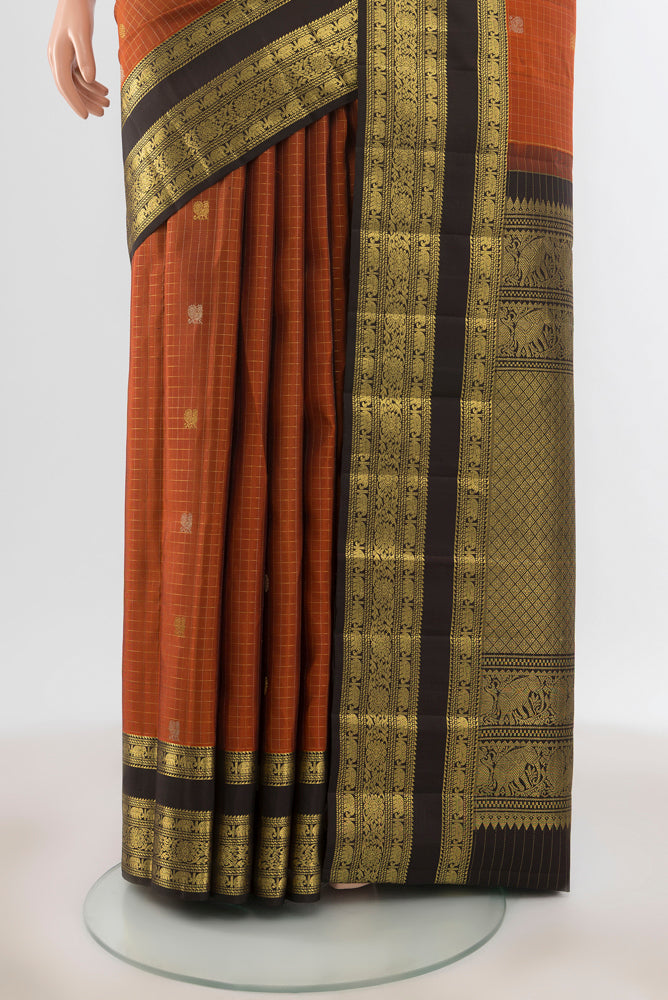 Pleats and pallu of Pure Silk Pure Zari Rust Kanjivaram Saree with Zari Butta on the body and Silk Border. 