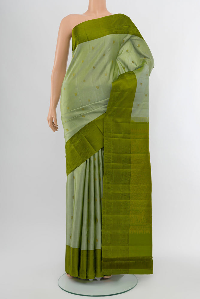 Light Green Kanchipuram Silk Saree with Zari Butta on the body and Silk Border.  displayed on a mannequin