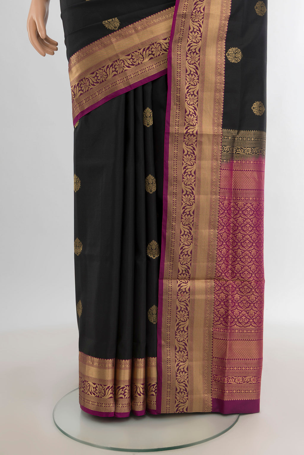 Pleats and pallu of Black Soft Silk Saree with Zari Butta on the body and Zari Border. 