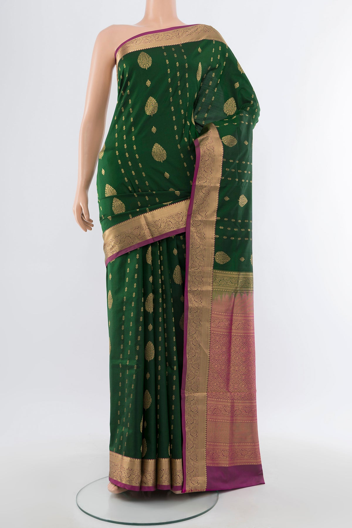 Bottle Green Soft Silk Saree with Zari Butta on the body and Silk Border.  displayed on a mannequin
