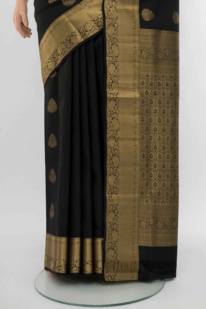 Pleats and pallu of Black Soft Silk Saree with Zari Butta on the body and Silk Border. 