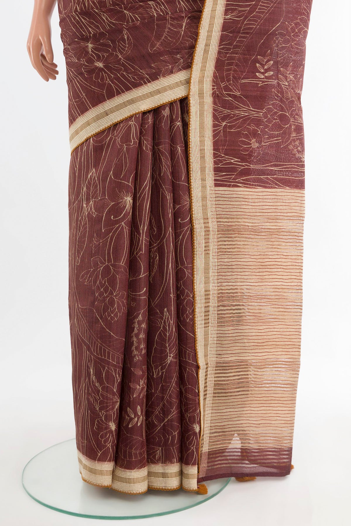 Pleats and pallu of Brown Tussar Saree with Printed design on the body and Thread Border. 