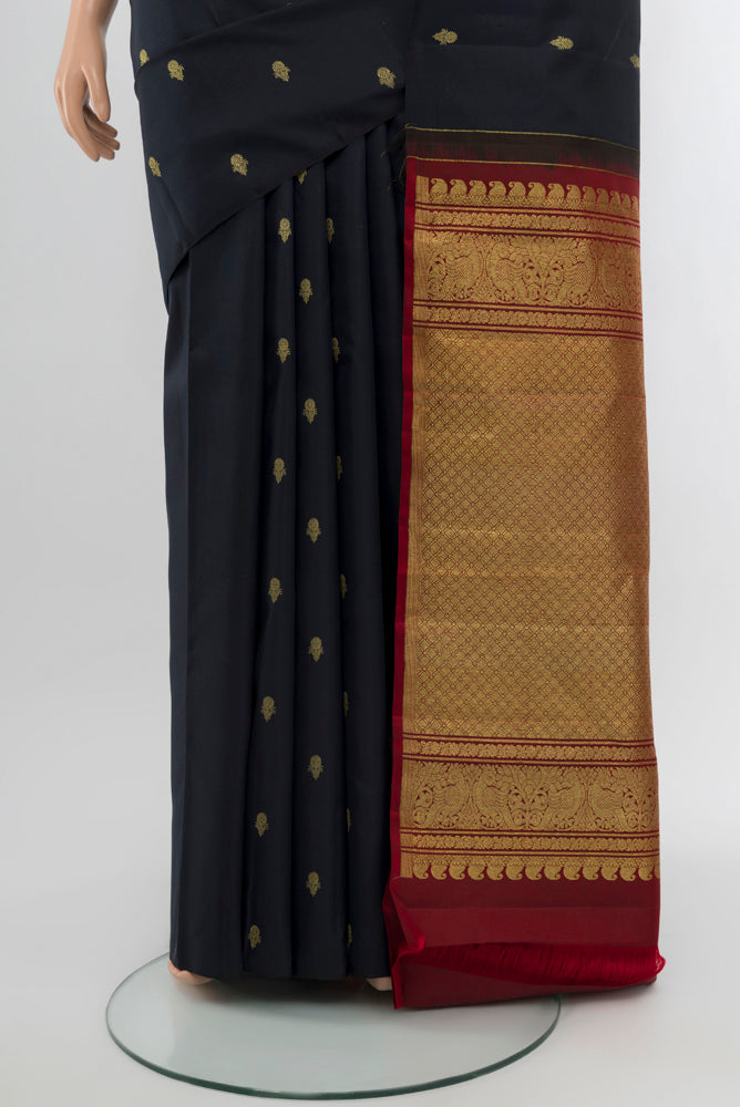 Pleats and pallu of Black Kanchipuram Silk Saree with Zari Butta on the body and Silk Border. 