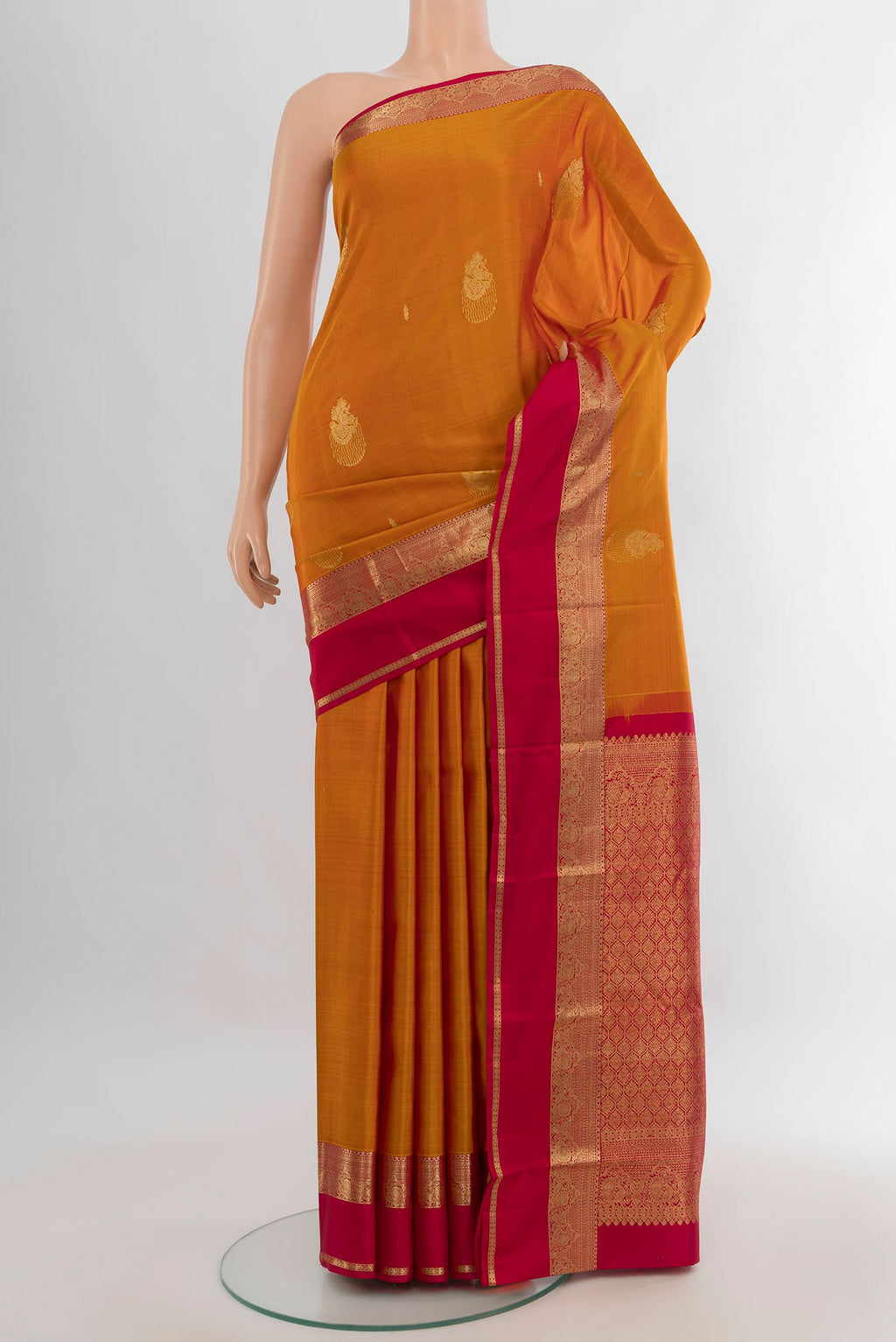 Pure Silk Mustard Kanjivaram Saree with Zari Butta on the body and Zari Border.  displayed on a mannequin