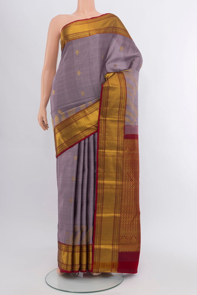 Lavender Kanjivaram Silk Saree with Zari Butta on the body and Silk Border.  displayed on a mannequin