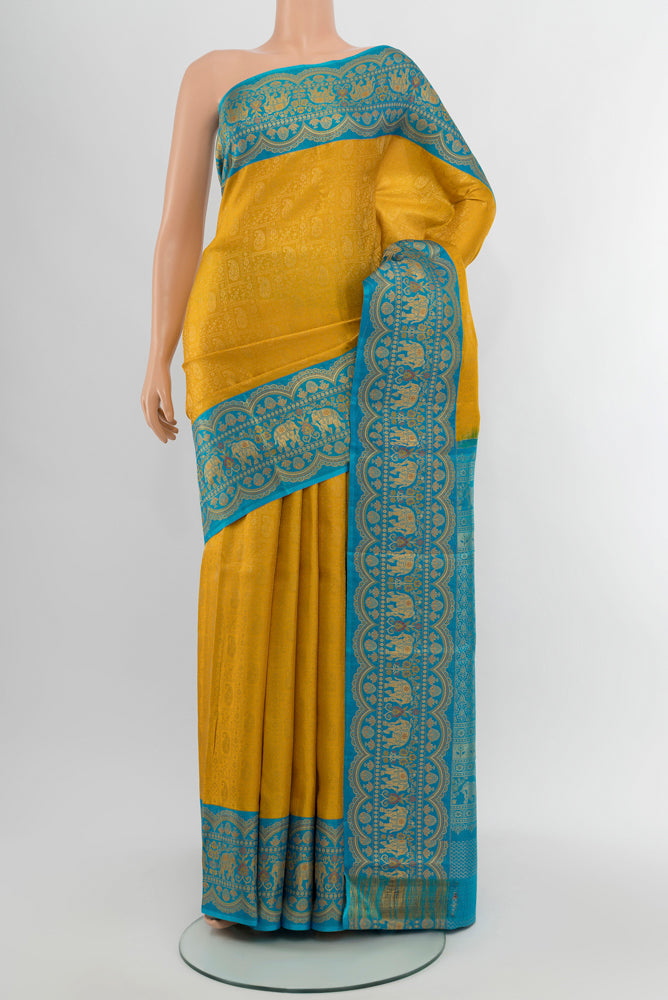 Mustard Kanjivaram Silk Saree with Zari Butta on the body and Silk Border.  displayed on a mannequin