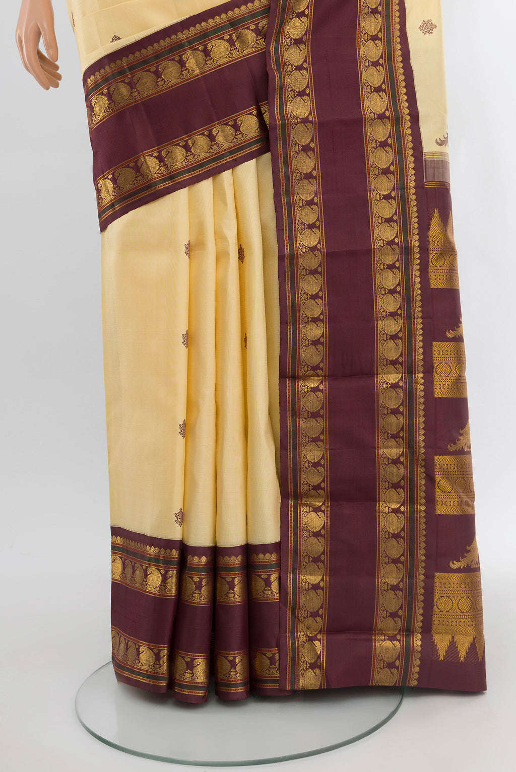 Pleats and pallu of Sandal Kanchipuram Silk Saree with Thread Butta on the body and Zari Border. 