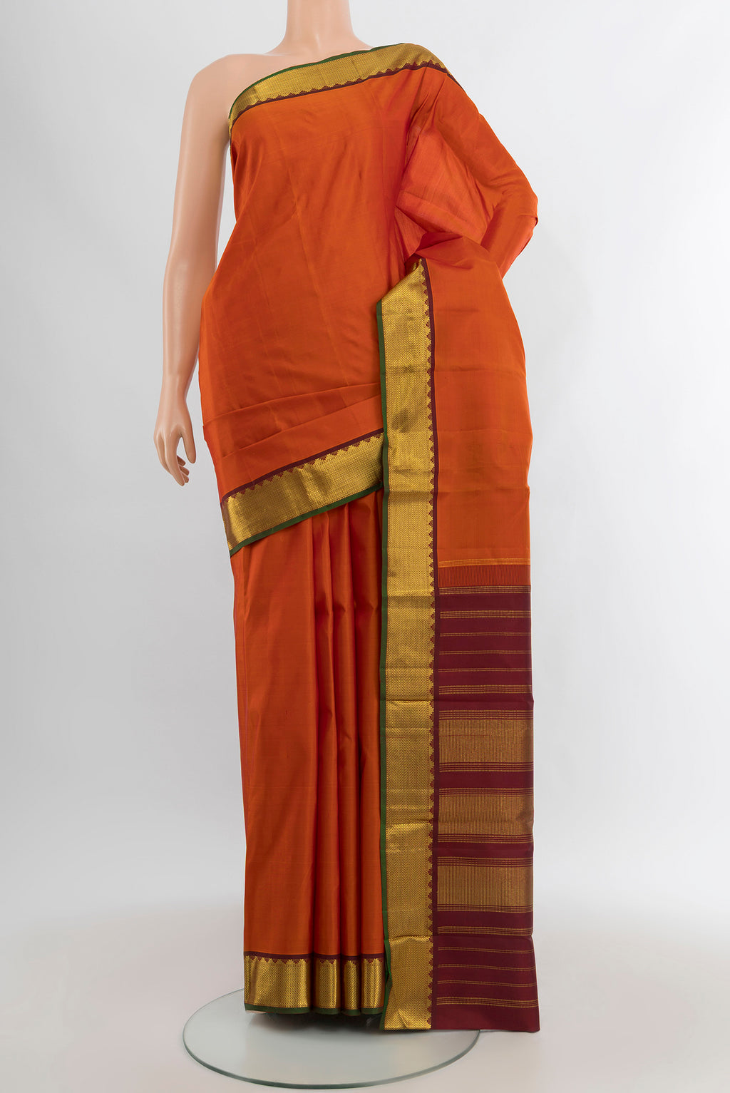 Rust Kanchipuram Silk Saree with Plain Body and Zari Border.  displayed on a mannequin